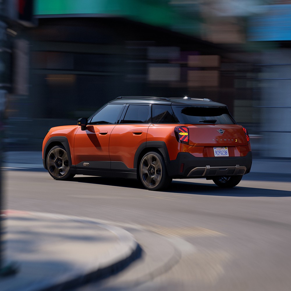 MINI Aceman a circular numa rua, com edifícios desfocados em segundo plano
